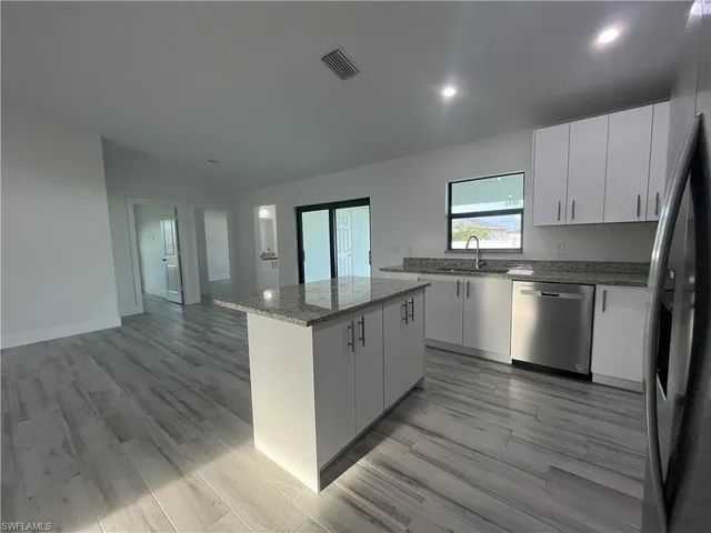 a bathroom with a granite countertop toilet and a sink