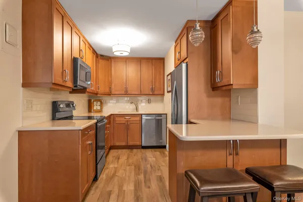 a kitchen with stainless steel appliances granite countertop a refrigerator a stove top oven a sink and dishwasher