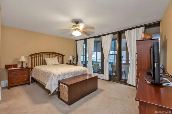 a bedroom with a large bed and a flat tv screen on dresser