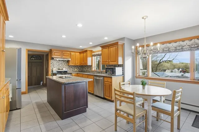 a kitchen with a stove a refrigerator a sink dishwasher with a dining table and chairs