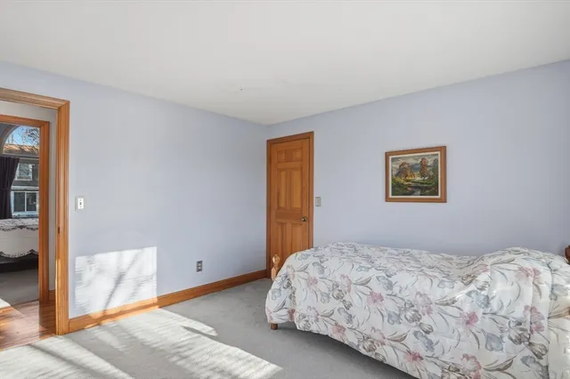 a bedroom with a bed and a painting on the wall