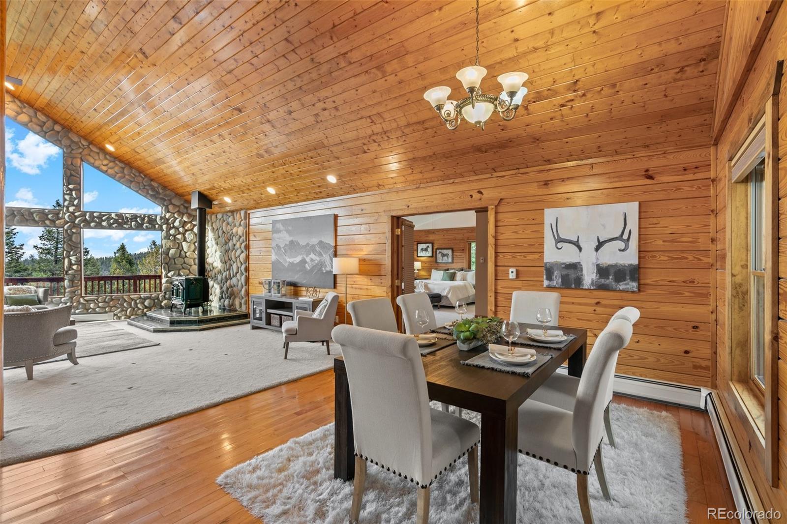 10248 Christopher Drive Conifer, CO 80433 - Photo 12 of 40 a living room with furniture a chandelier and a large window