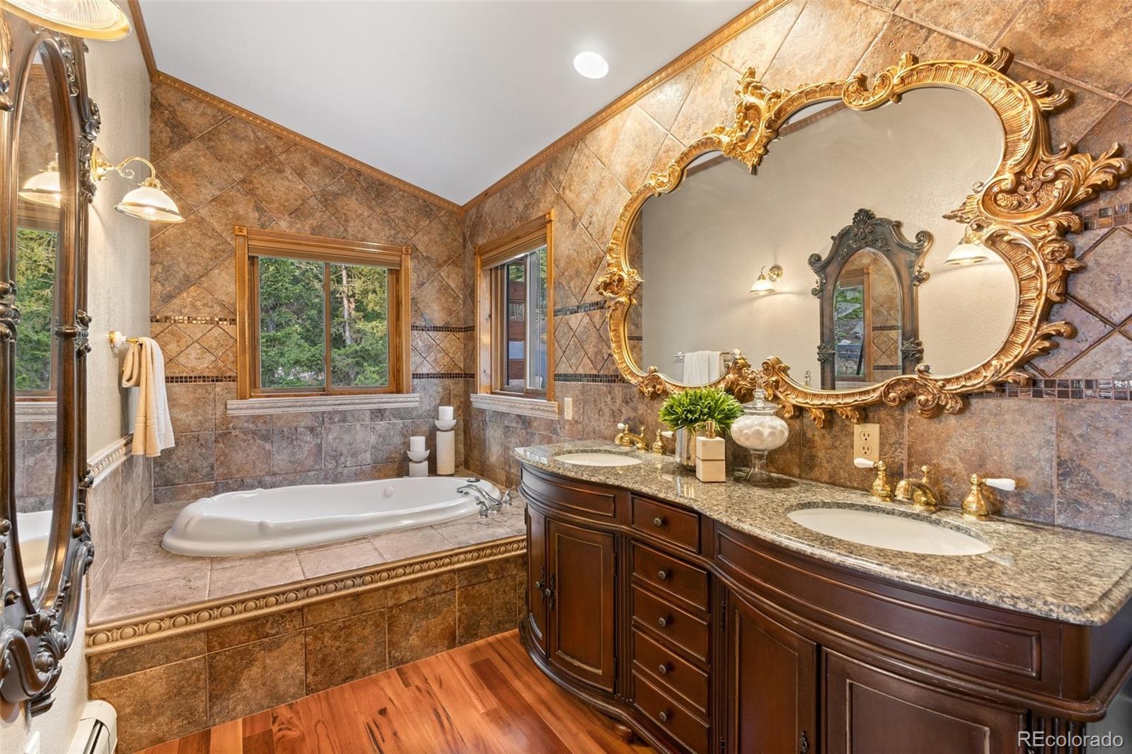 10248 Christopher Drive Conifer, CO 80433 - Photo 15 of 40 a bathroom with a granite countertop sink a mirror and bathtub