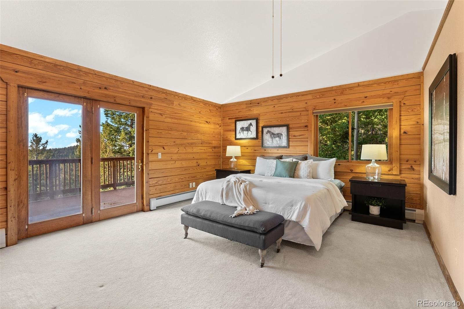 10248 Christopher Drive Conifer, CO 80433 - Photo 18 of 40 a spacious bedroom with a bed and large glass window