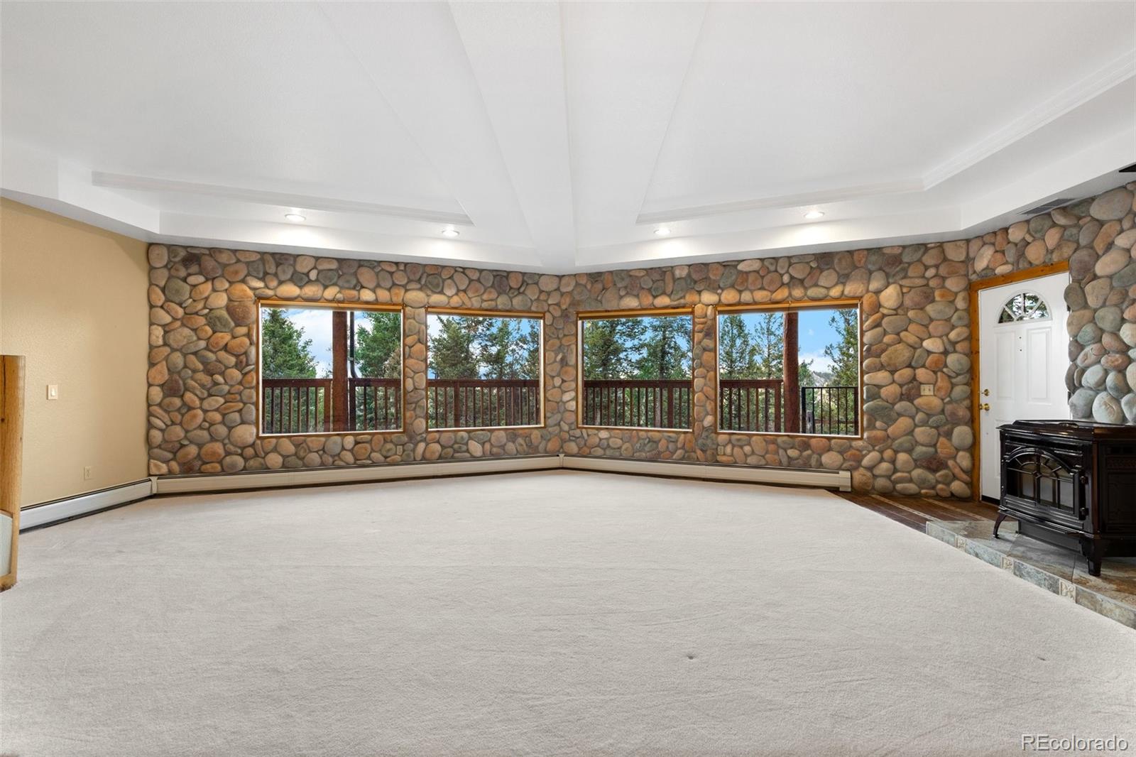 10248 Christopher Drive Conifer, CO 80433 - Photo 29 of 40 a view of an empty room with a fireplace and a large window