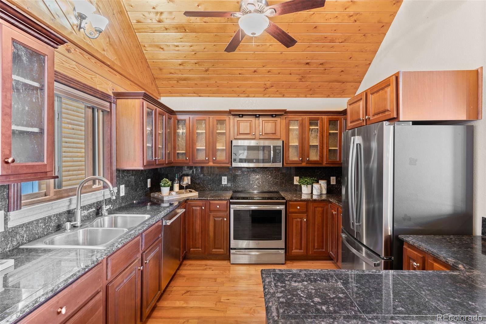 10248 Christopher Drive Conifer, CO 80433 - Photo 5 of 40 a kitchen with stainless steel appliances granite countertop a sink stove and refrigerator