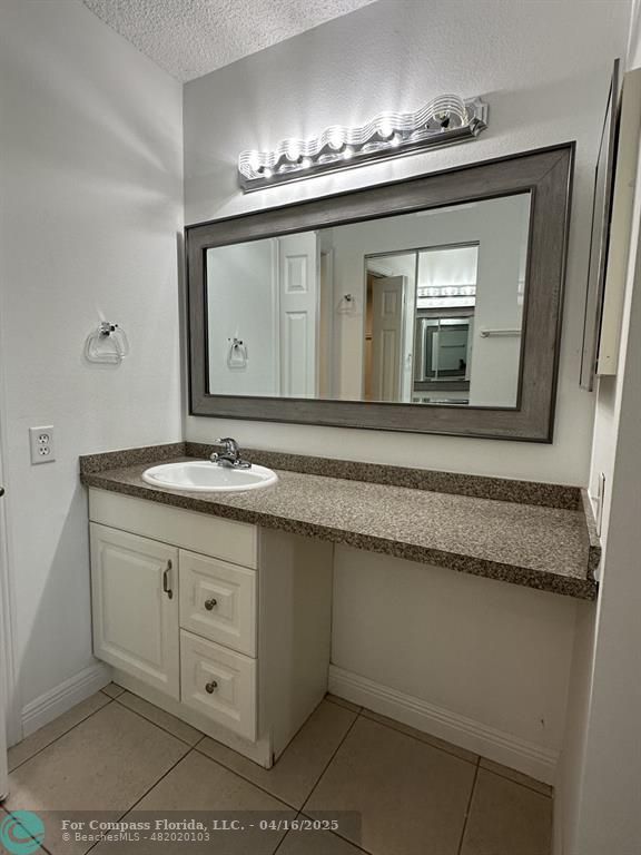 9401 Lime Bay Boulevard, Unit 115 Tamarac, FL 33321 - Photo 11 of 18 a bathroom with a double vanity sink and a mirror