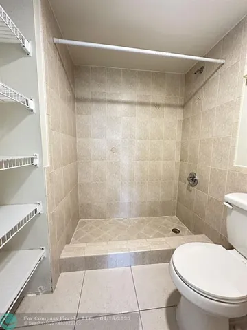 a bathroom with a granite countertop bathtub shower and toilet