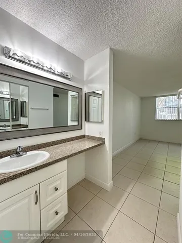 a spacious bathroom with a granite countertop sink a mirror and a