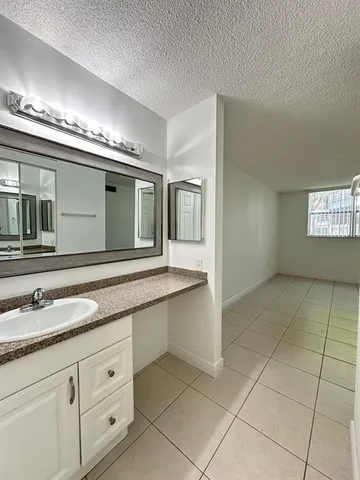 a spacious bathroom with a granite countertop sink a mirror and a