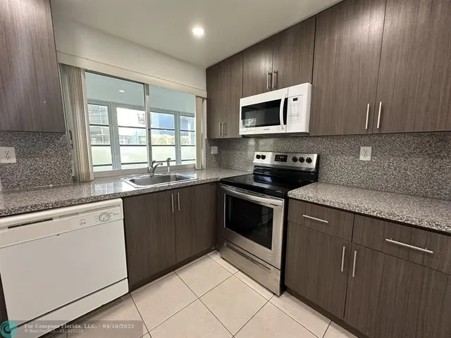 a kitchen with stainless steel appliances granite countertop a sink and a stove