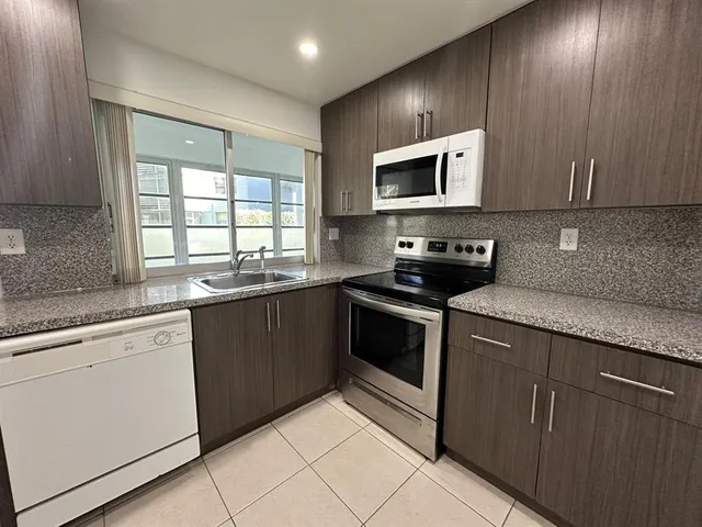 a kitchen with stainless steel appliances granite countertop a sink and a stove