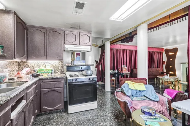 a living room with lots of furniture and kitchen view