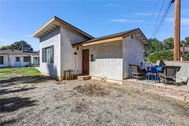 a view of a house with backyard and sitting area