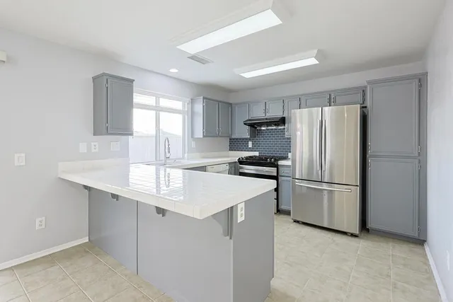 a kitchen with a refrigerator a sink a stove a microwave and cabinets