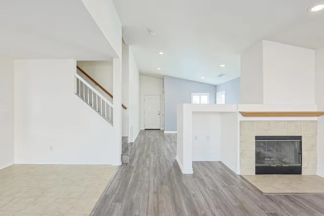 a view of empty room with wooden floor and fireplace