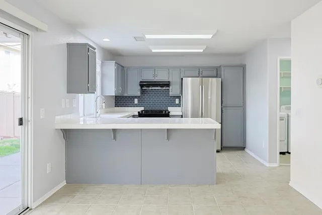 a kitchen with kitchen island a sink stainless steel appliances and cabinets