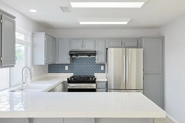a kitchen with stainless steel appliances a refrigerator sink and cabinets