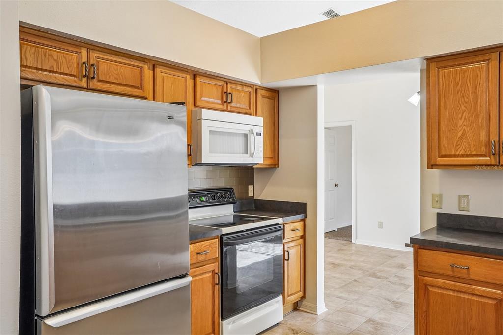 2596 Alclobe Circle Ocoee, FL 34761 - Photo 23 of 70 a kitchen with stainless steel appliances granite countertop a refrigerator and a stove