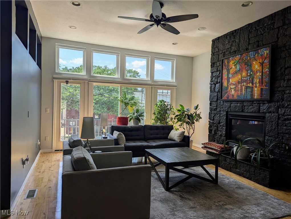 1949 Columbus Road Cleveland, OH 44113 - Photo 3 of 25 Living area with a stone fireplace, light wood-style flooring, ceiling fan, and recessed lighting