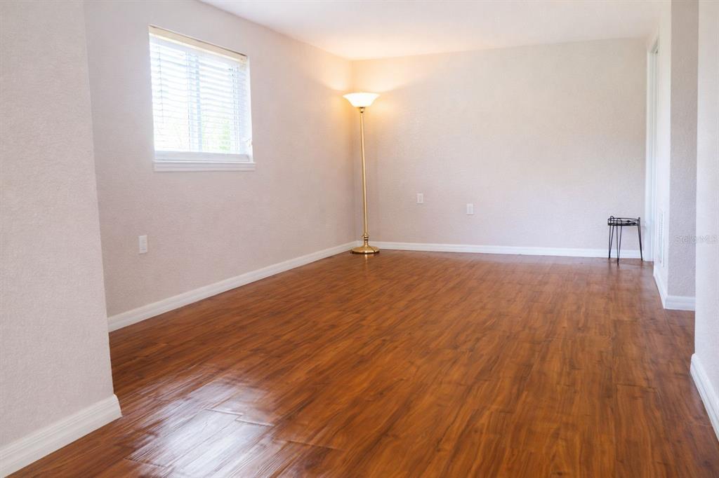 445 State Rte 415 Osteen, FL 32764 - Photo 11 of 25 an empty room with wooden floor and windows
