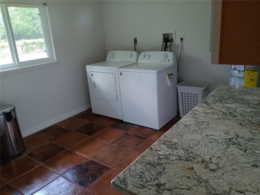 445 State Rte 415 Osteen, FL 32764 - Photo 16 of 25 a utility room with a washer dryer and a rug