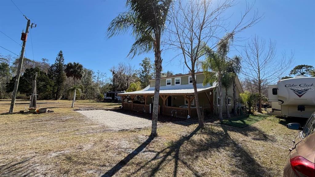 445 State Rte 415 Osteen, FL 32764 - Photo 4 of 25 a view of a house with backyard porch and sitting area