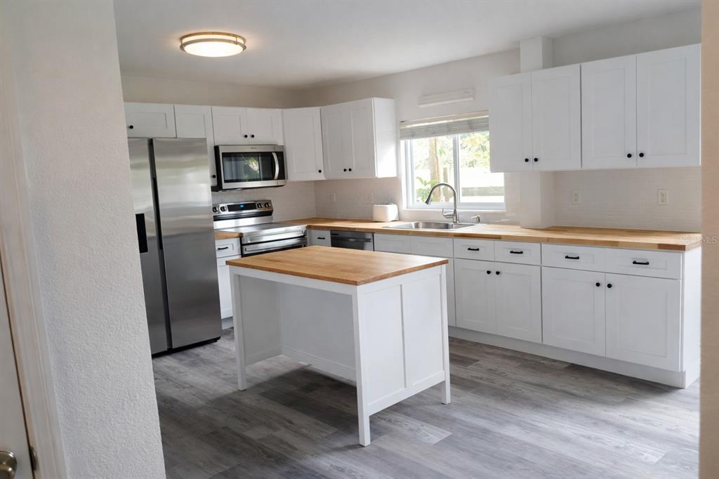 445 State Rte 415 Osteen, FL 32764 - Photo 6 of 14 a kitchen with cabinets appliances a sink and a window