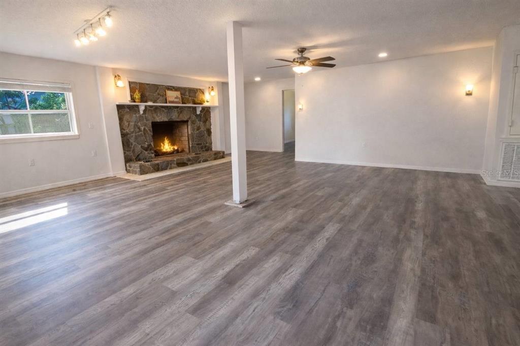 445 State Rte 415 Osteen, FL 32764 - Photo 8 of 14 an empty room with wooden floor fire place and windows