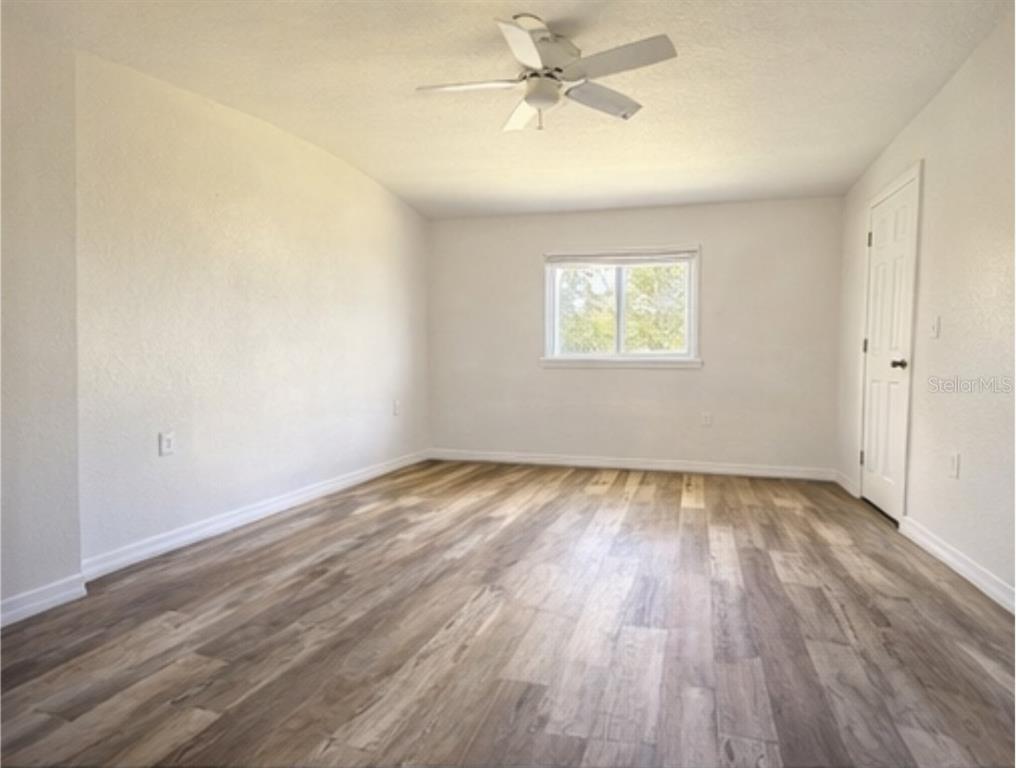 445 State Rte 415 Osteen, FL 32764 - Photo 10 of 14 wooden floor in an empty room with a window