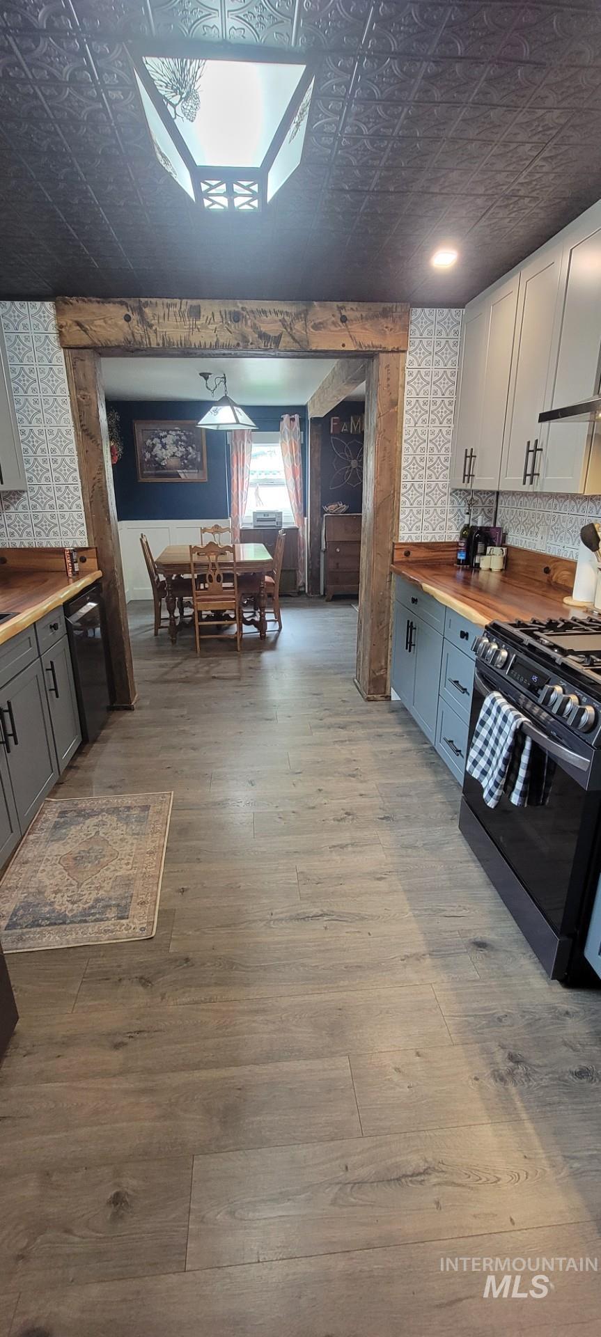 1006 Borah Avenue Riggins, ID 83549 - Photo 11 of 24 Two tone kitchen with wood counters, an ornate ceiling, gas stove, light wood-style flooring, and decorative backsplash