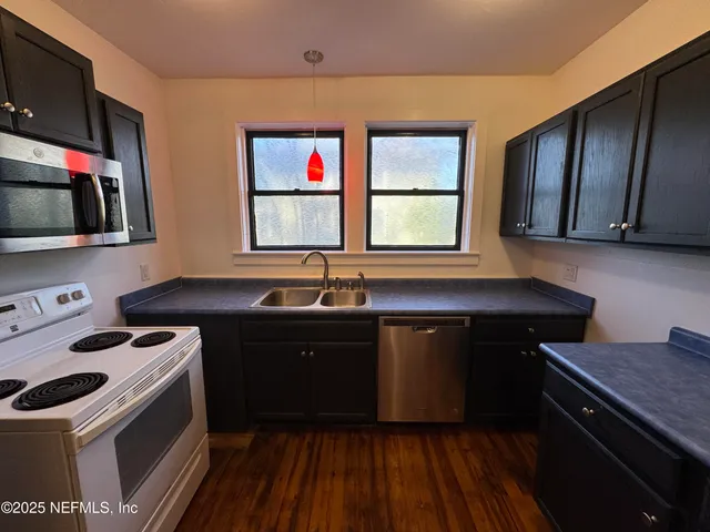 a kitchen with a sink stove and microwave