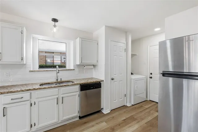 a kitchen with a refrigerator a sink and cabinets