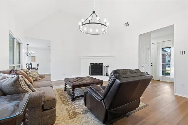 a living room with furniture a fireplace and a chandelier