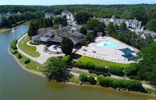 an aerial view of a house with a garden and lake view