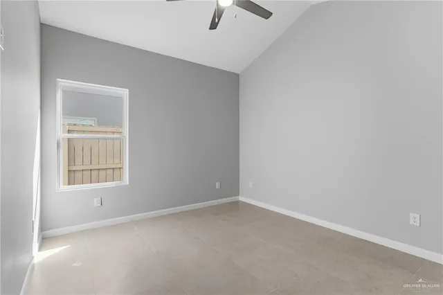 an empty room with ceiling fan and window