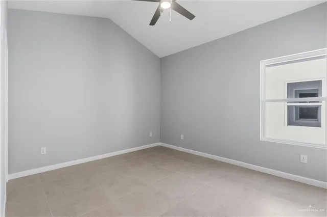 an empty room with a window and ceiling fan