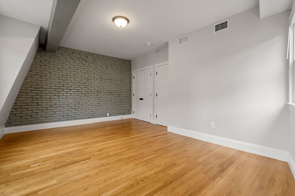 129 Sutherland Road, Unit A Boston, MA 02135 - Photo 15 of 38 a view of empty room with wooden floor