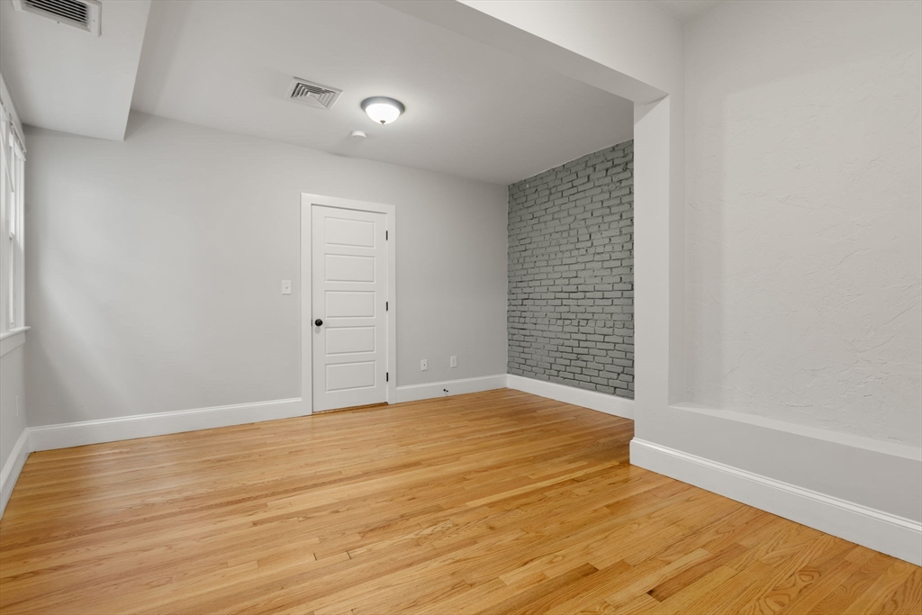 129 Sutherland Road, Unit A Boston, MA 02135 - Photo 19 of 38 a view of an empty room with wooden floor