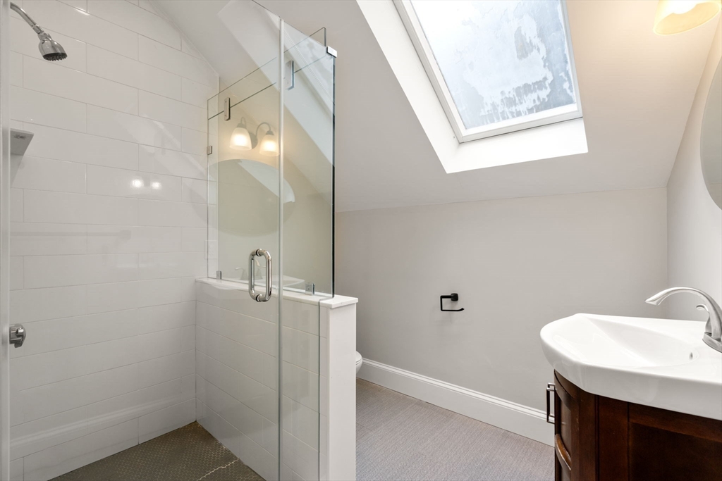 129 Sutherland Road, Unit A Boston, MA 02135 - Photo 22 of 38 a bathroom with a sink mirror and vanity