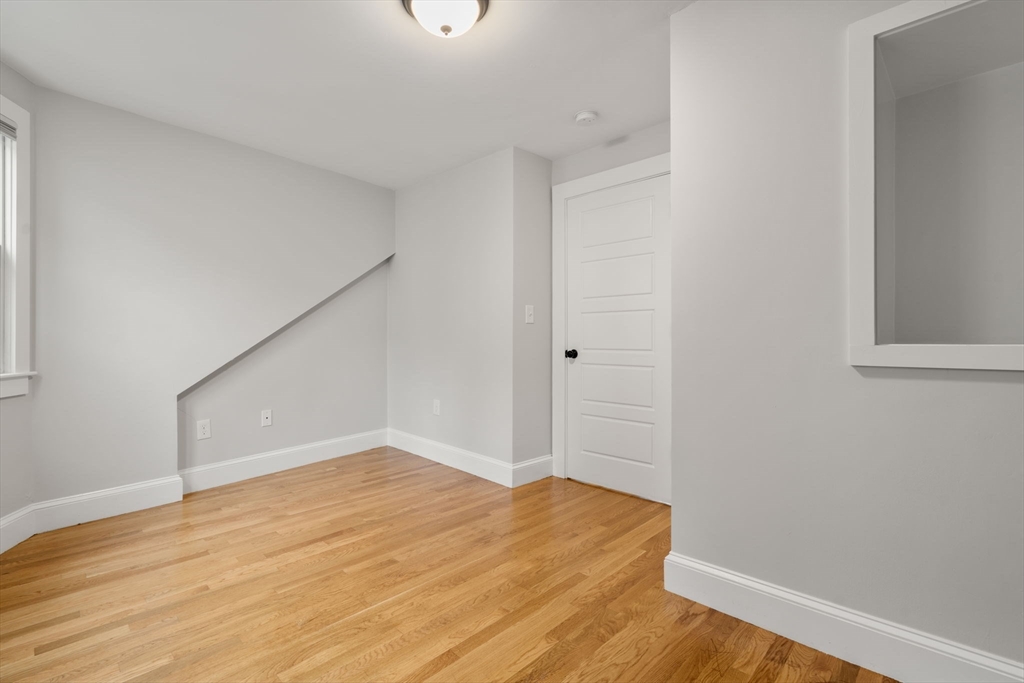129 Sutherland Road, Unit A Boston, MA 02135 - Photo 27 of 38 a view of empty room with wooden floor