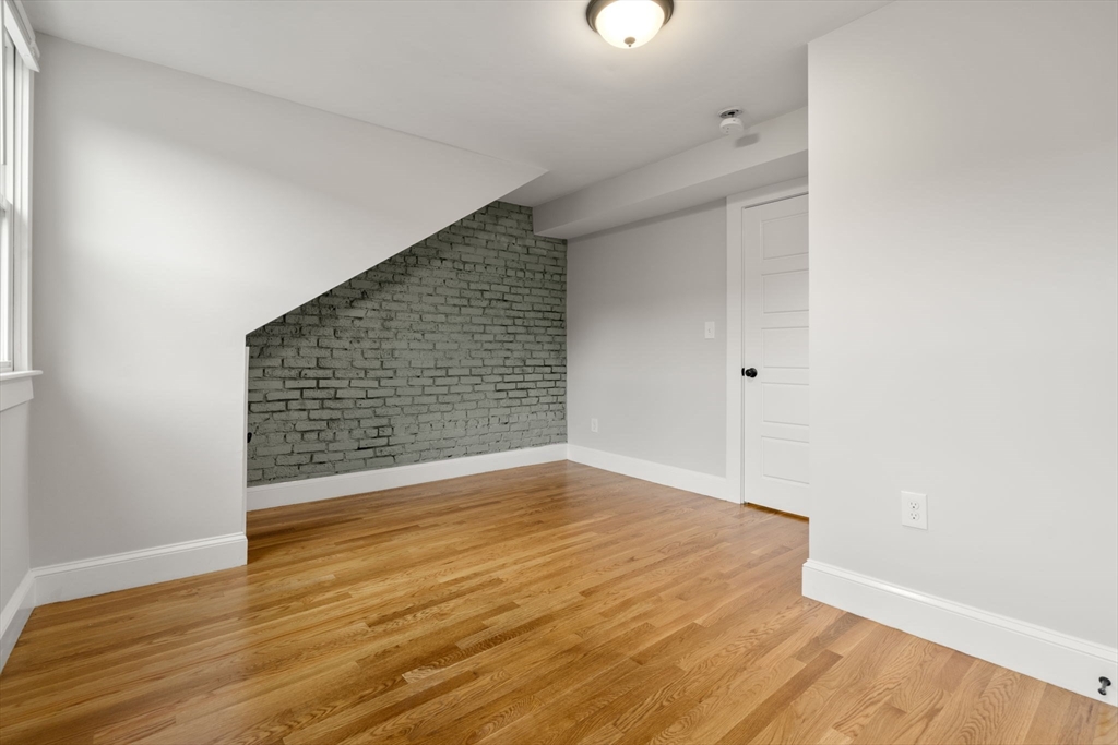 129 Sutherland Road, Unit A Boston, MA 02135 - Photo 31 of 38 a view of an empty room with wooden floor