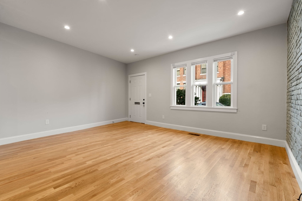 129 Sutherland Road, Unit A Boston, MA 02135 - Photo 4 of 38 a view of empty room with wooden floor and fan
