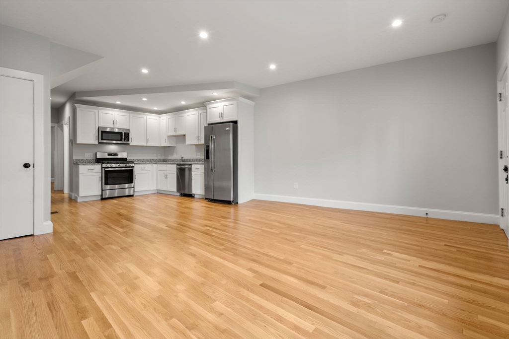 129 Sutherland Road, Unit A Boston, MA 02135 - Photo 5 of 38 a view of kitchen with stainless steel appliances wooden floor and large window