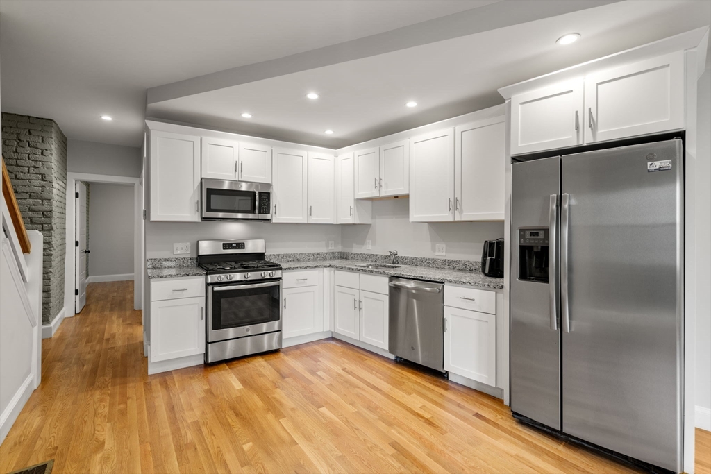 129 Sutherland Road, Unit A Boston, MA 02135 - Photo 7 of 38 a kitchen with a refrigerator a stove top oven a sink and dishwasher