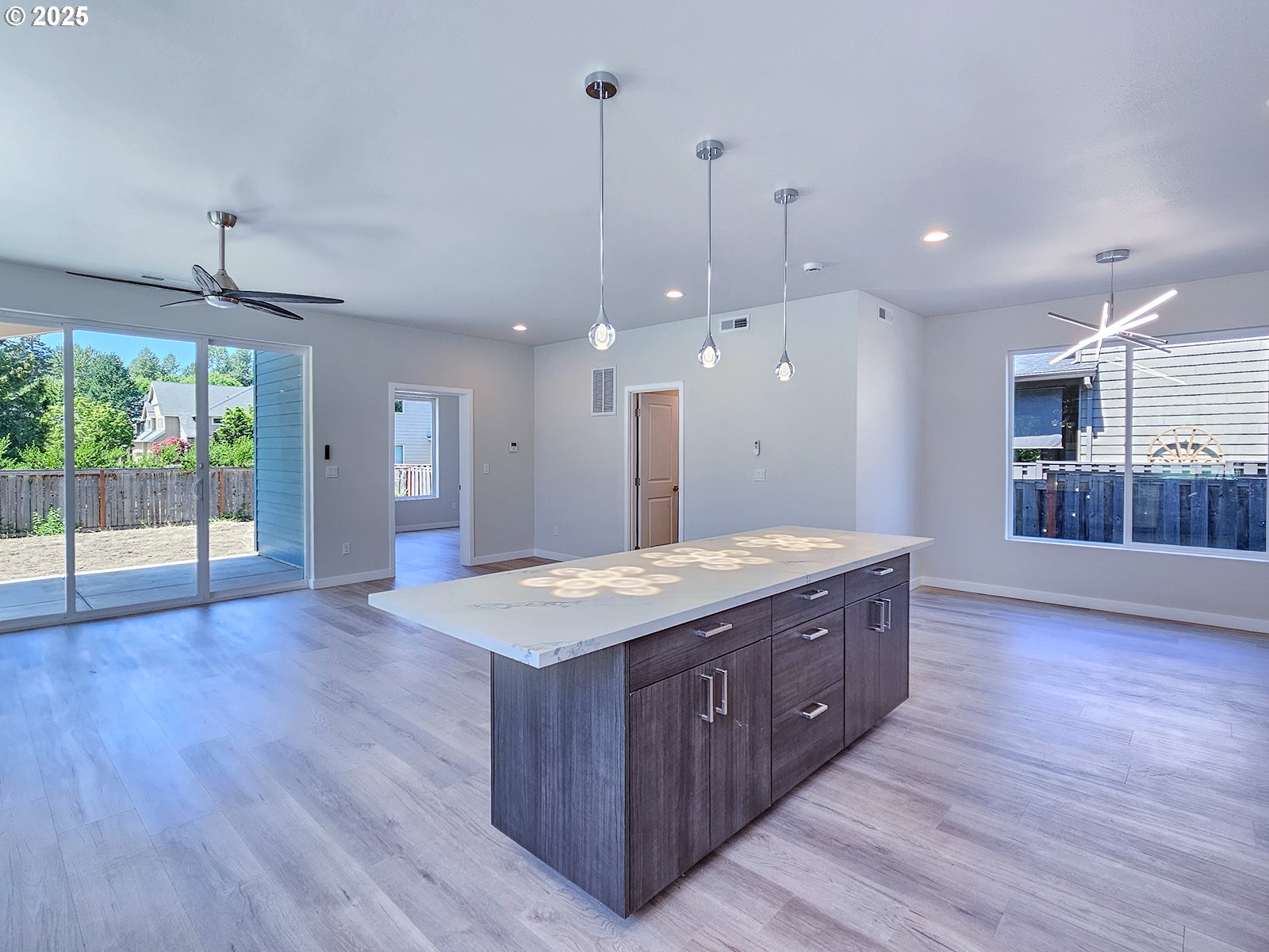 28683 Southwest Canyon Creek Road Wilsonville, OR 97070 - Photo 22 of 29 a spacious kitchen with stainless steel appliances granite countertop wooden floors wooden cabinets a center island and a refrigerator
