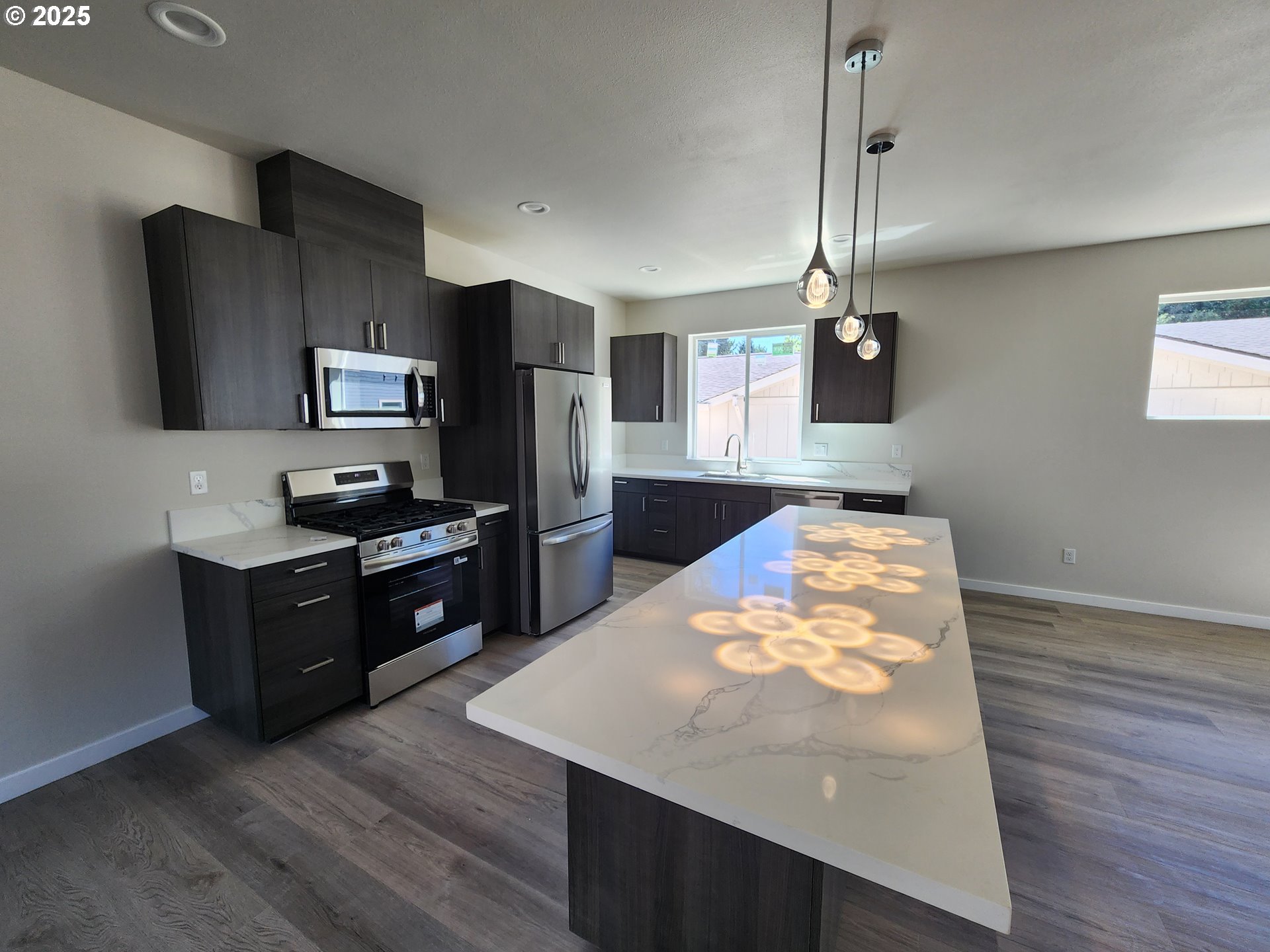 28683 Southwest Canyon Creek Road Wilsonville, OR 97070 - Photo 4 of 29 a kitchen with stainless steel appliances granite countertop a sink refrigerator and microwave