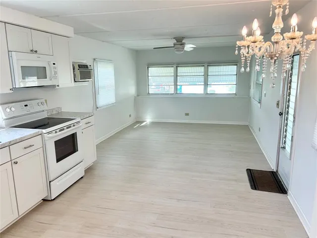 a view of a kitchen with a stove cabinets and a floor to ceiling window