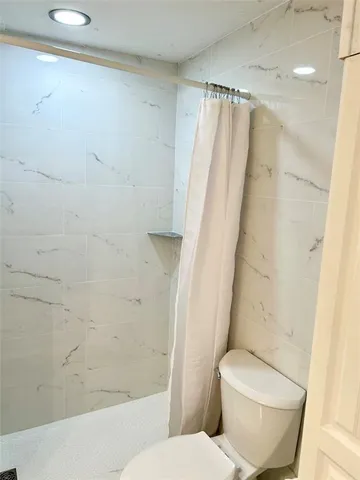 a white toilet sitting next to a bath tub
