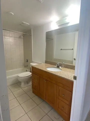 a spacious bathroom with a granite countertop sink toilet and shower